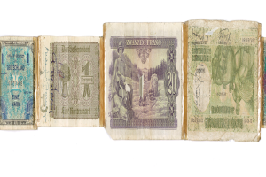 Ein altes Buch mit einer Sammlung von deutschen Banknoten verschiedener Nennwerte, die von 1 bis 99 auf ihm verteilt sind.