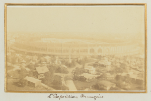 Altes Schwarz-Weiß-Foto eines Stadions, umgeben von Stadtgebäuden, Bäumen und Masten mit Text unten.