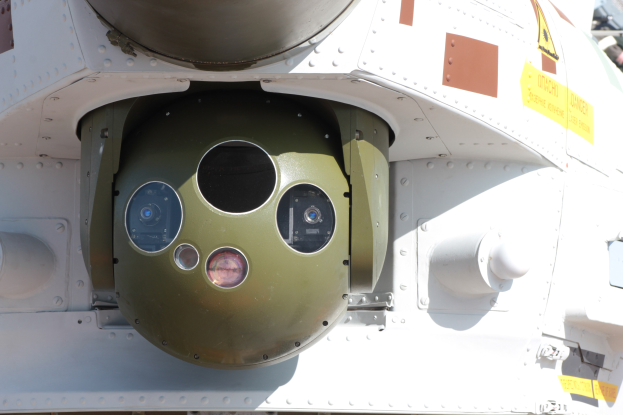 Nahaufnahme eines Militärfahrzeugs mit einer grün-weißen Kreisrakete, die seitlich in einem Metallrahmen montiert ist.