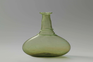 Ein grüner Glasweinkelch mit Verschluss, zylindrischer Form, breiter Basis, engem Hals und detaillierten Verzierungen, mit glänzender Oberfläche.