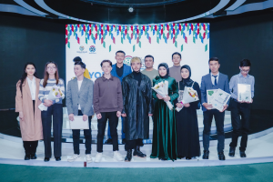 Gruppe von Menschen auf einer Bühne mit Blumensträußen und Urkunden, vor dem Hintergrund "Jugend-Solar-Awards 2019"