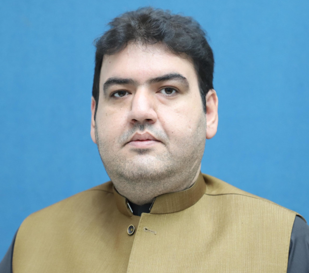 Ein Mann in einer braunen Weste und schwarzem Hemd steht vor einem blauen Hintergrund und sieht bedrückt und verzweifelt aus, wahrscheinlich wegen einer lebenslangen Haftstrafe.