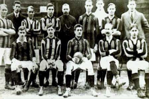 Ein Schwarz-Weiß-Foto einer Fußballmannschaft, die vor einer Wand steht oder sitzt, mit dem Text "Ballymena Football Club" unten.