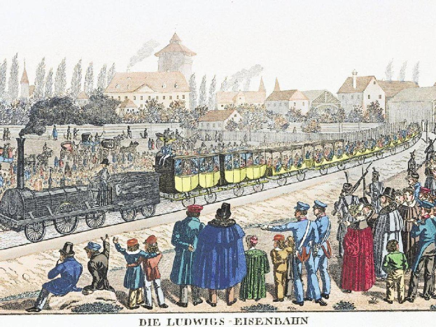 Eine Gruppe von Menschen steht um einen Zug auf einem Gleis, einige sind im Zug, andere außerhalb, in der Nähe von Gebäuden und Bäumen, mit dem Text "Ludwigs-Eisenbahn, die erste Bahnstation Deutschlands" unten.