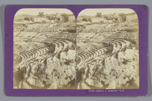 Schwarz-weiß-Stereoskopische Ansichten eines antiken Amphitheaters in Syrakus, das Sitzreihen aus Stein, umgebende Gebäude, Bäume und Himmel zeigt.