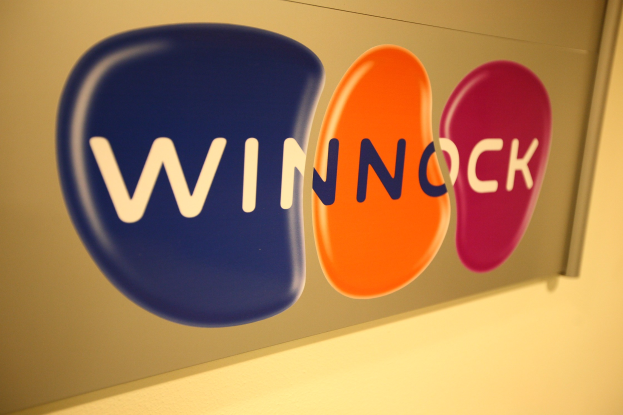 Buntes "Winnock"-Schild an einer Wand, das einen Aktienmarkt anzeigt.