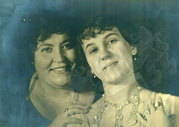 Zwei Frauen lächeln warm in einem alten Foto, ihre strahlenden Augen voller Leben.