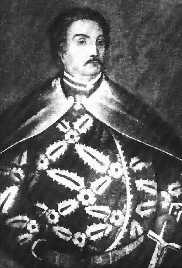 Schwarzes und weißes Foto von Papst Johannes Paul II. in Priesterroben, der eine schwarze Robe mit weißem Kragen und Manschetten trägt und die Hände falt, mit ernstem Gesichtsausdruck und direktem Blick.