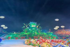 Ein farbenfroher Karneval in Rio de Janeiro, Brasilien, mit Performern in bunten Kostümen auf der Bühne, einer großen Menge im Publikum und einem Himmel voller farbiger Lichter und Ballons.