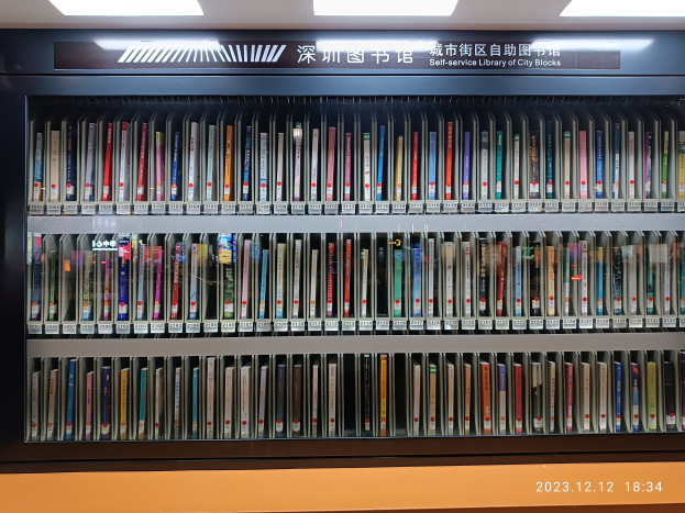 Eine gut beleuchtete Bibliothek mit Reihen von Bücherregalen voller Bücher, ein sichtbares Textbrett und ein Wasserzeichen unten.