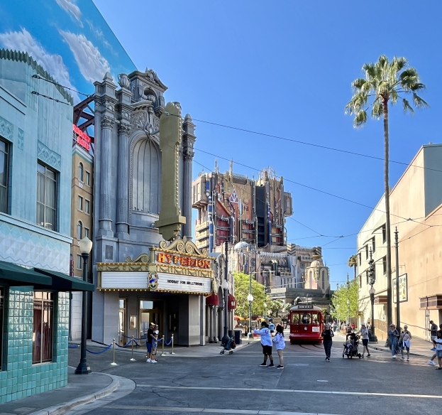 Lebendige StraßenSzene im Universal Studios Hollywood mit Passanten, einem Fahrzeug, Bäumen, Straßenmöbeln und einem sichtbaren Himmel.