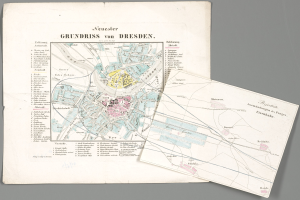 Ein detaillierter alter Stadtplan von Dresden, Deutschland, mit zwei Papieren im Vordergrund vor einem grauen Hintergrund.