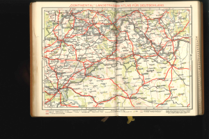Offenes Buch mit einer detaillierten Karte von Deutschlands Straßen und Autobahnen vor einem schwarzen Hintergrund.