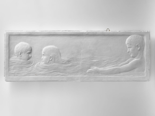 Drei Kinder beim Schwimmen in einem Pool, mit einer Wand im Hintergrund, dargestellt auf einem Schwarz-Weiß-Foto.