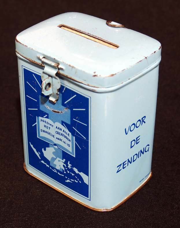 Weißer und blauer Blechspartopf mit einem blauen und weißen "Voor de Zending" Schild, das auf einer schwarzen Oberfläche steht.